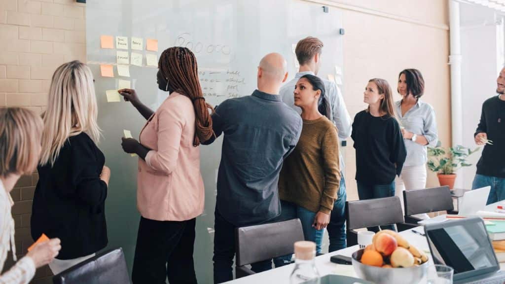 Engineering team collaborating around a whiteboard during a technical alignment session.