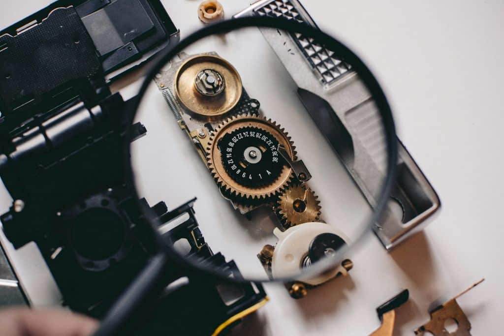 Close-up of mechanical gears viewed through a magnifying glass, symbolizing how observability reveals hidden system behaviour.<br />
Image of Observability foundation training