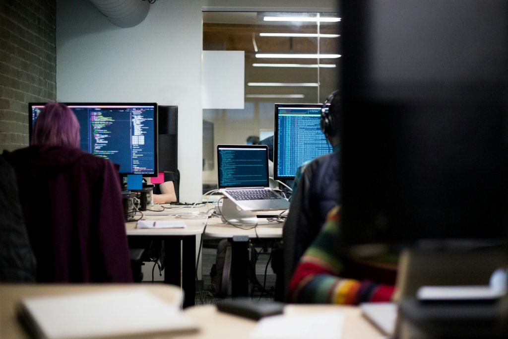 Engineers working in an office with multiple monitors, illustrating real‑world development and system behaviour analysis.<br />
Image of Performance Testing foundation training